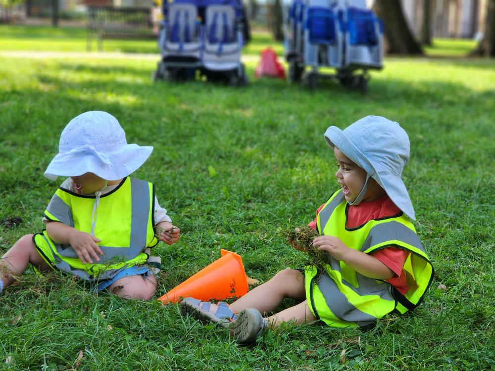 Young children exploring natural materials together outdoors at L&L Academy Lincoln Park